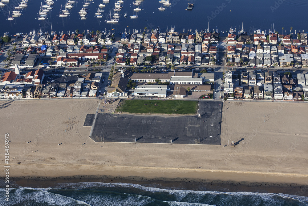 Aerial view of beach front homes, boats and school in the Newport Beach area of Orange County, California.