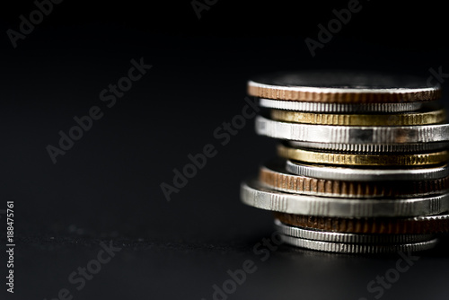 Closeup of coins stack isolated on black background photo