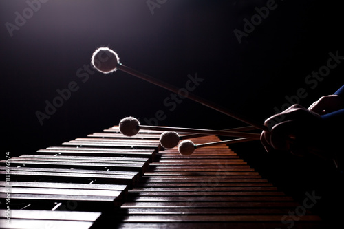 Fototapete The hands of a musician playing the marimba in dark tones