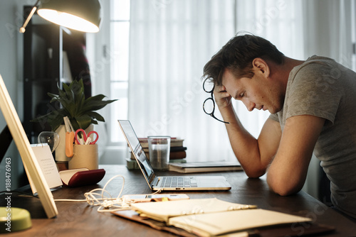 Man stressed while working on laptop photo