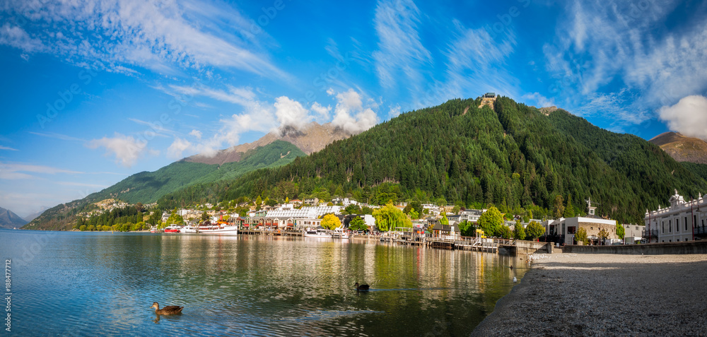 View of the alpine city of Queenstown in New Zealand, from the marina bay of Lake Wakatipu with the Queenstown Skyline mountain in the background.