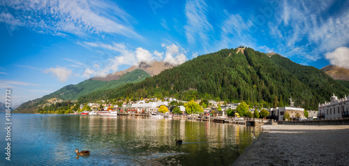 View of the alpine city of Queenstown in New Zealand, from the marina bay of Lake Wakatipu with the Queenstown Skyline mountain in the background.