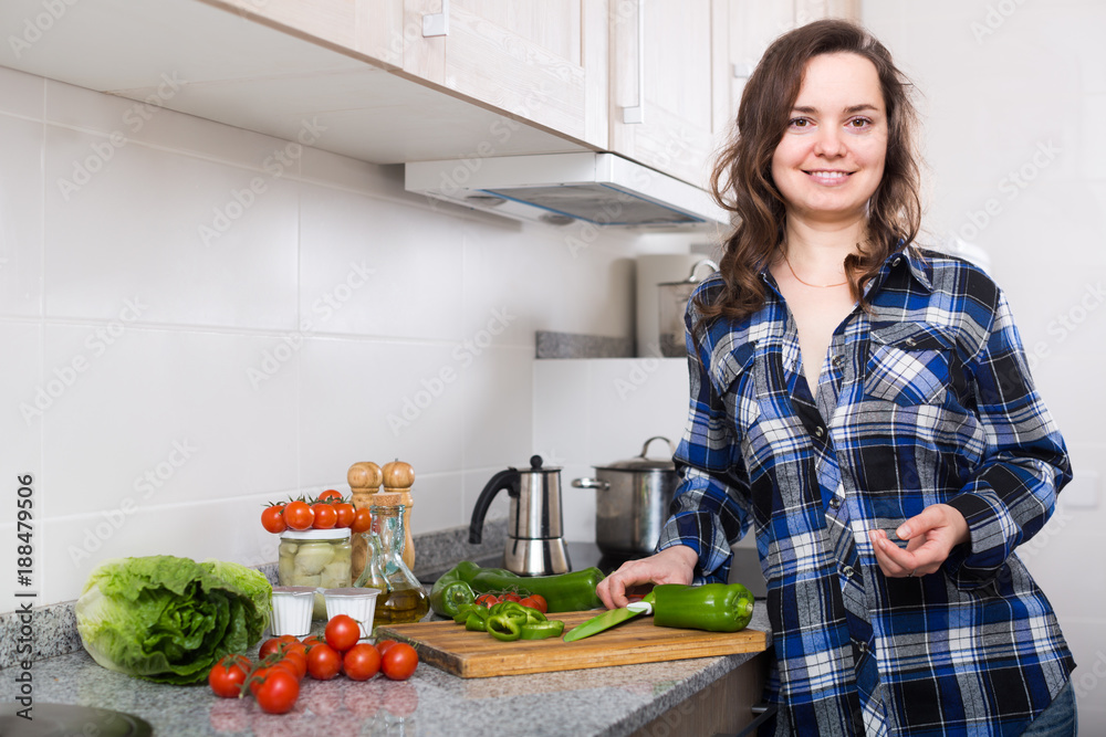 Happy woman preparing veggies at home.