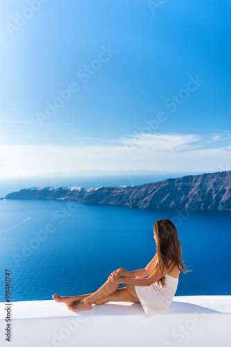 Photography Luxury travel vacation Europe tourist woman relaxing at fancy hotel resort balcony in greek Santorini island, Greece with view over the Mediterranean Sea and Oia