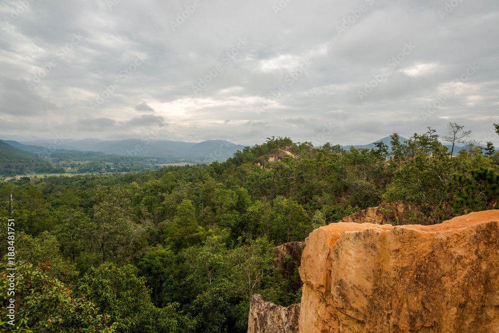 Naklejka premium Soil Cliff Phenomenon by nature in the hill of forest mountain with cloudy sky, countryside at the north of Thailand (Mae Hong Son)