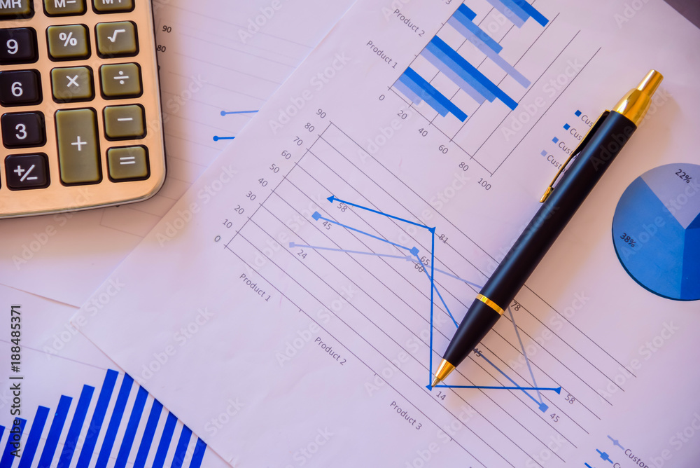 Obraz premium Pen on diagram chart and graphs business report with money, compass, calculator on desk of financial advisor. Accounting and Financial Planning Concept. top view.