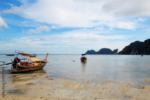 The view on the long boats on a coast of sea on a low tide. Island Phi Phi, Thailand.