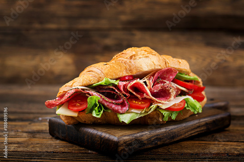 Tasty breakfast. Appetizing croissant with salami and, cheese and tomatoes