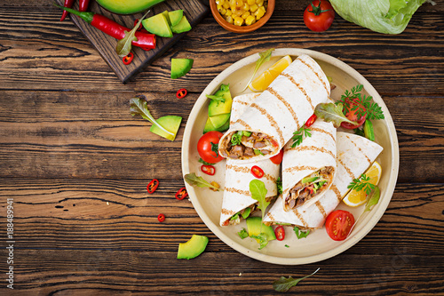 Burritos wraps with beef and vegetables on a wooden background. Beef burrito , mexican food. Healthy food background. Mexican cuisine.Top view.