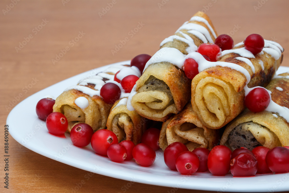 Traditional sweet rolled pancakes with poppy seeds on the plate