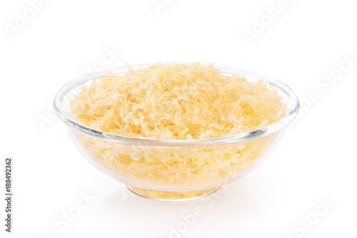 Grated parmesan cheese in a glass bowl isolated on white background.