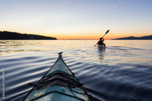 Adventure Woman Kayaking on a Sea Kayak during a Vibrant Sunset. Taken near Jericho Beach, Vancouver, BC, Canada. photo