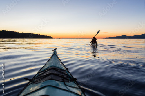 Adventure Woman Kayaking on a Sea Kayak during a Vibrant Sunset. Taken near Jericho Beach, Vancouver, BC, Canada.