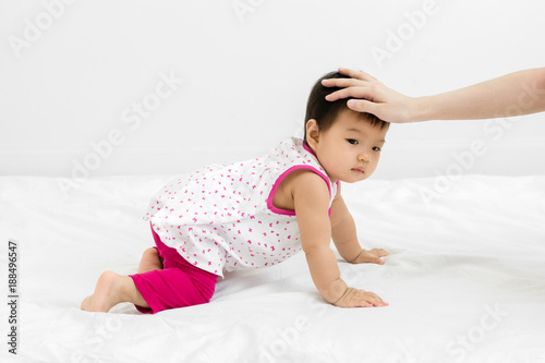 Portrait of adorable baby girl crawling on the bed, indoors