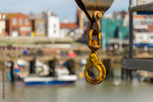 A rusty crane hook with blurry background of Bridlington harbour, East Riding of Yorkshire, UK