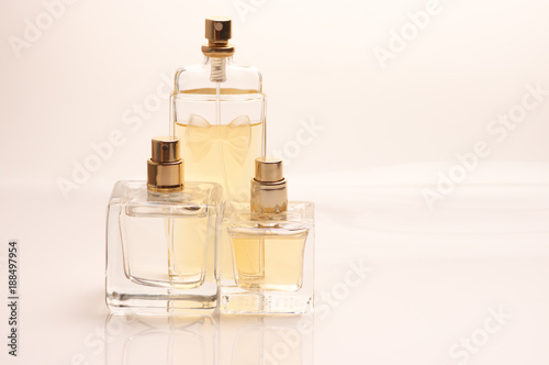 Three pastel colored perfume bottles