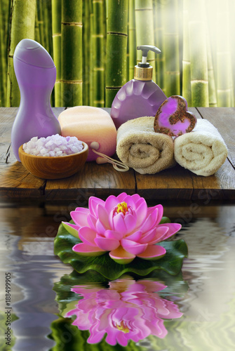 Spa composition on a wooden background and lotus flower on the water.