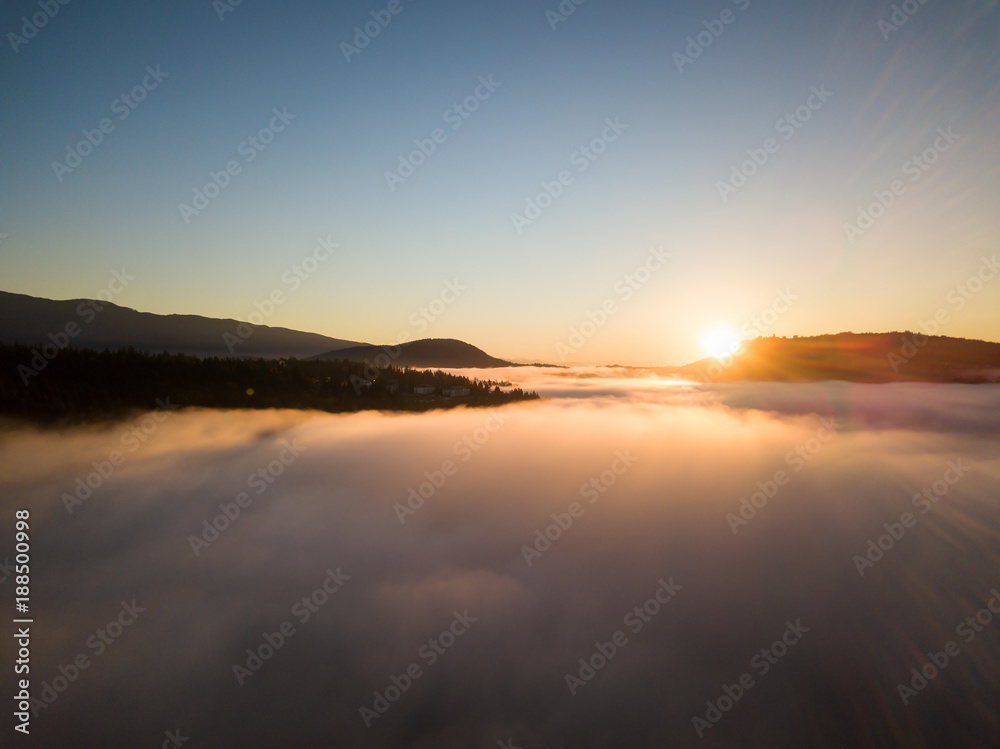 Aerial view of the fog covering North Vancouver, British Columbia, Canada, during a vibrant sunrise