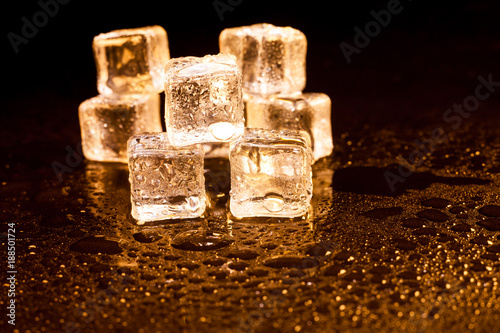 Golden ice cubes on black background.
