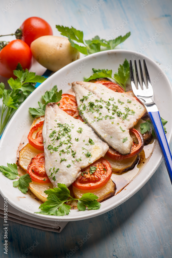 fish with potatoes and tomatoes, selective focus fish with potatoes and tomatoes, selective focus