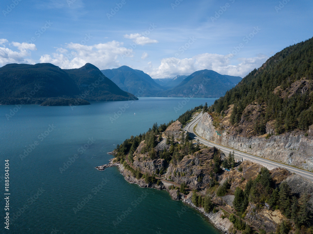 Aerial view of Sea to Sky Highway in Howe Sound during a vibrant sunny summer day. Taken North of Vancouver, BC, Canada.