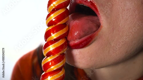 A charming European adult woman of 35-40 years erotically sucks a large lollipop.