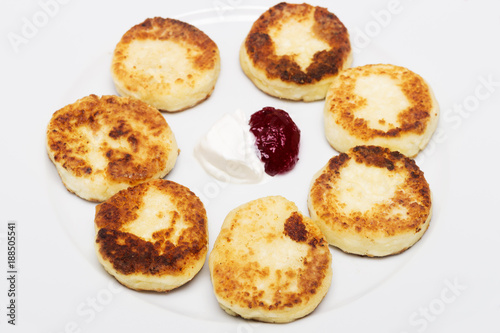 cheese pancakes on the palte with jam and sour cream. top view