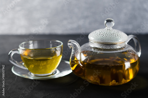 Cup of delicious herbal tea and glass teapot.