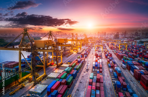 Logistics and transportation of Container Cargo ship and Cargo plane with working crane bridge in shipyard at sunrise, logistic import export and transport industry background