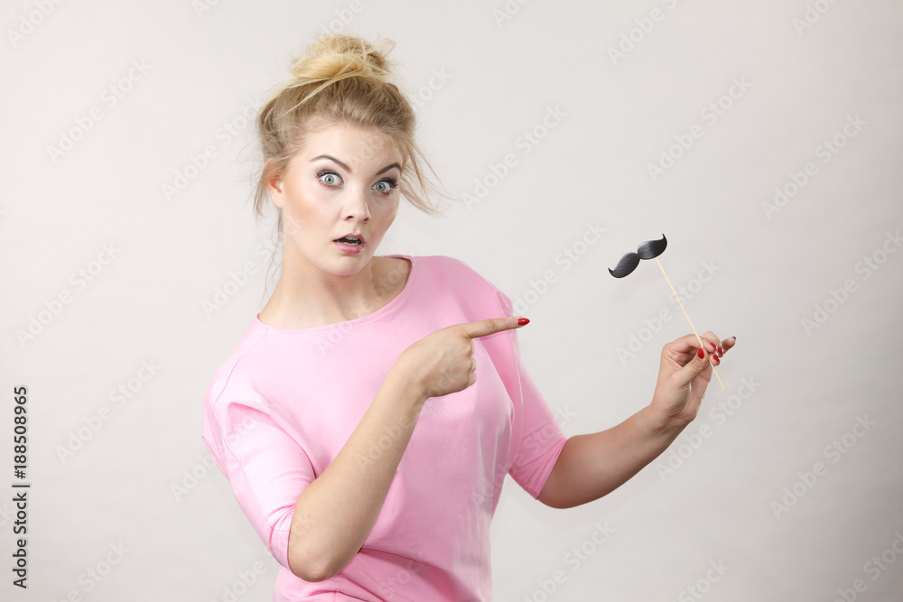 Happy woman holding fake moustache on stick Happy woman holding fake moustache on stick