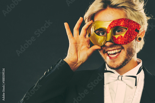 Man in carnival mask with heart stick love symbol