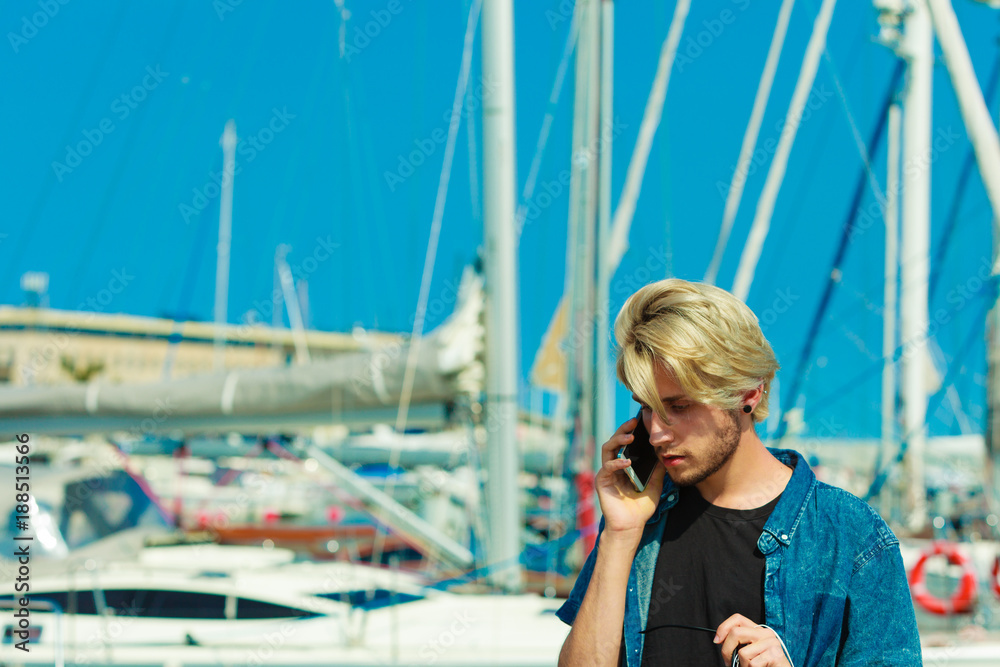 Blonde man talking on mobile phone