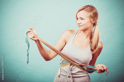 Fitness girl measuring her body with tapes
