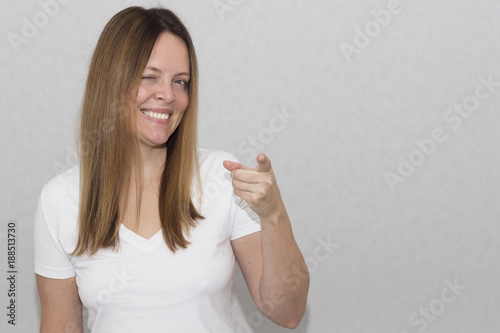 Pretty cheerful woman gesturing with fingers and showing away