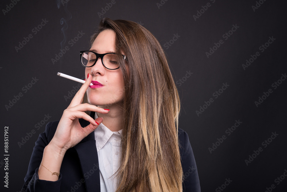 Elegant manager girl wearing glasses and smoking cigarette foto de Stock |  Adobe Stock
