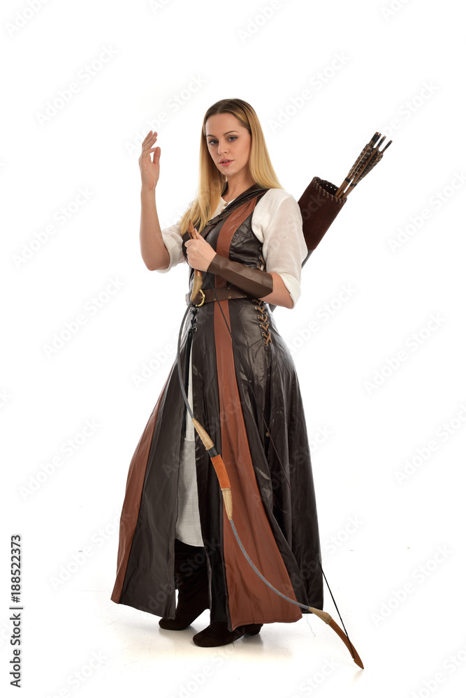 full length portrait of girl wearing brown fantasy costume, holding a bow and arrow. standing pose on white studio background. full length portrait of girl wearing brown fantasy costume, holding a bow and arrow. standing pose on white studio background.
