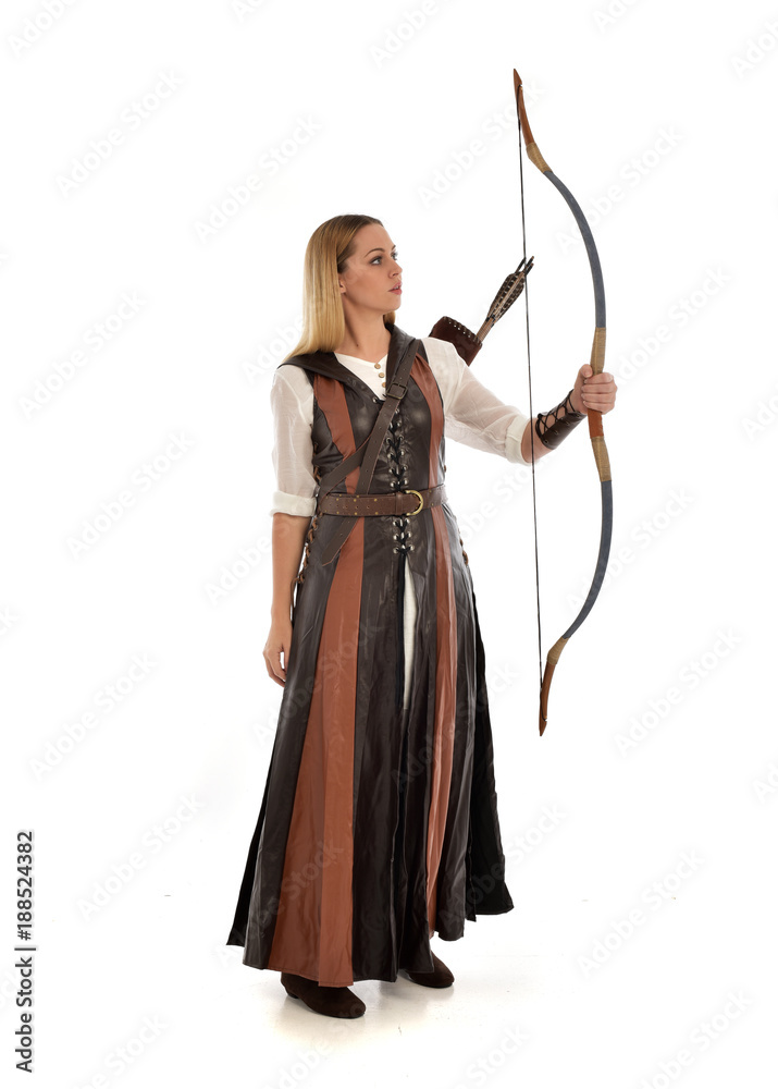 full length portrait of girl wearing brown fantasy costume, holding a bow and arrow. standing pose on white studio background. full length portrait of girl wearing brown fantasy costume, holding a bow and arrow. standing pose on white studio background.