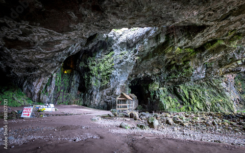 Smoo Cave, Durness, Scotland. The outer chamber of Smoo Cave on the Scottish north coast with a covered walkway leading to the inner cave.