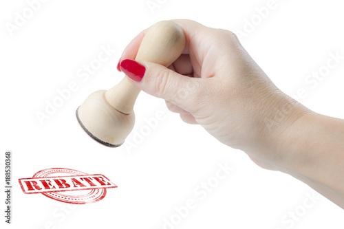 Hand holding a rubber stamp with the word rebate