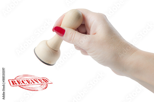 Hand holding a rubber stamp with the word received
