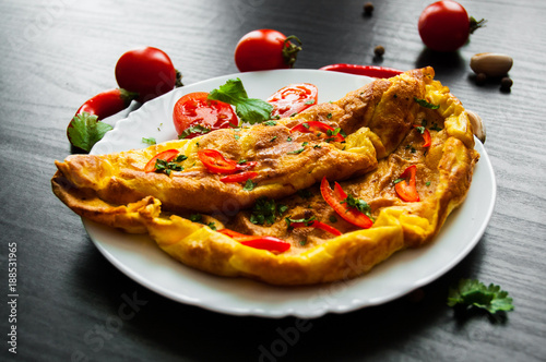 omelette in a plate on dark wooden background