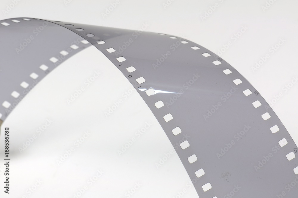 Fototapeta premium Twisted gray film strip on white background.