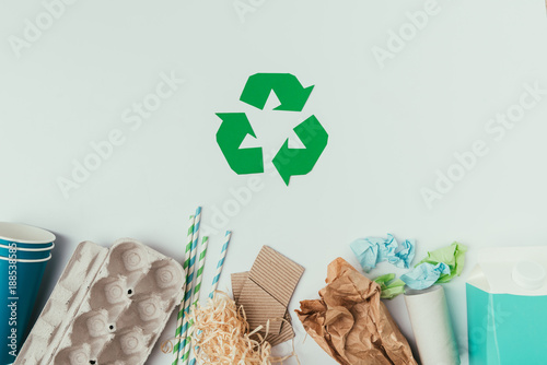 flat lay with various types of garbage and recycle sign isolated on grey photo