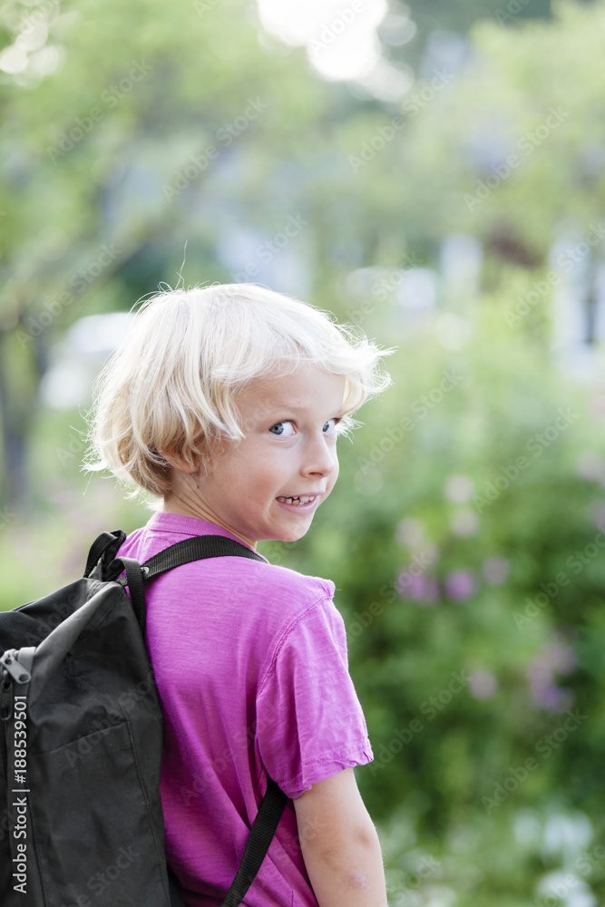 Little blonde boy with backpack looking at camera Little blonde boy with backpack looking at camera