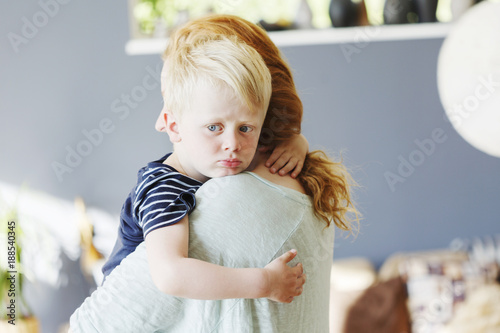 Mother holding and comforting disappointed baby sonÂ  photo