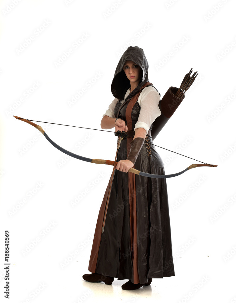 full length portrait of girl wearing brown fantasy costume, holding a bow and arrow, on white studio background. full length portrait of girl wearing brown fantasy costume, holding a bow and arrow, on white studio background.