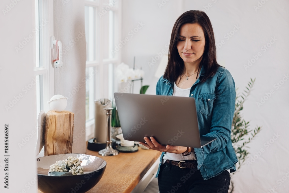Woman using a handheld laptop at home Woman using a handheld laptop at home