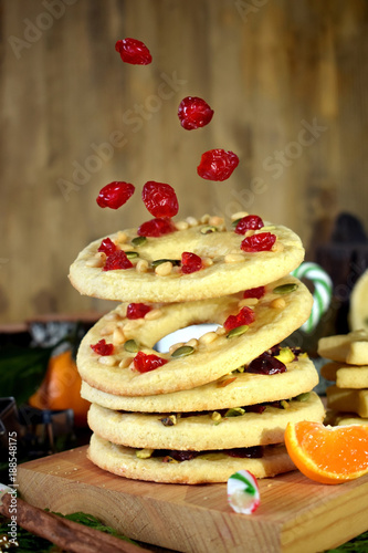 Flying shortbread cookies shaped as rings decorated with dried cherries and nuts. Levitating food