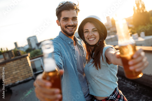 Happy couple enjoying drinks and balcony