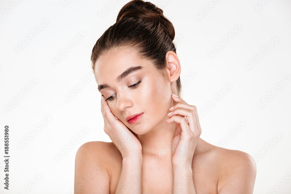 Horizontal portrait of tender woman being half-naked posing over white background with face downward touching her face Horizontal portrait of tender woman being half-naked posing over white background with face downward touching her face